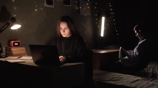 一个年轻的女生晚上坐在大学宿舍的房间里 用笔记本电脑在网上查找信息 过度工作导致剧烈头痛 复制空间 — 图库视频影像
