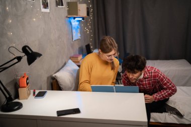 College students prepare for exam together in dormitory room. Copy space