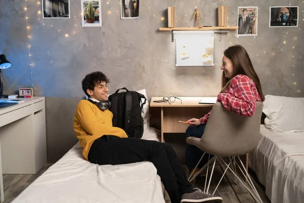 Man and woman students communicate in a dorm room. Friends spend time together in a hostel. copy space