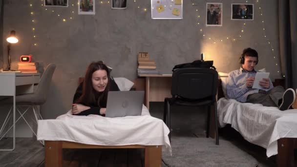 年轻的女学生晚上躺在大学宿舍的床上打一个视频电话 复制空间 — 图库视频影像