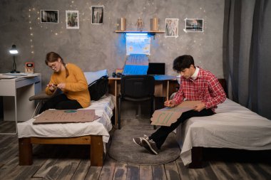 Activists in student dormitory prepare banners for protesting over pollution and global warming. Protest to save planet earth. Handwriting a banner of There is no Planet B. Copy space