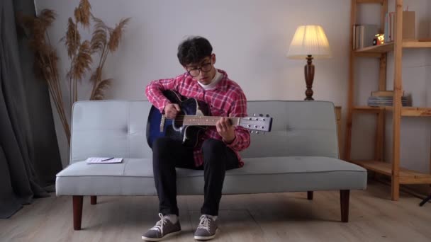 Handsome Young Man Playing Guitar Couch Home Copy Space — Stockvideo