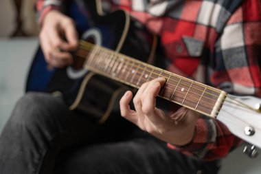 Practicing in playing guitar. Close up of male hands playing guitar. Copy space