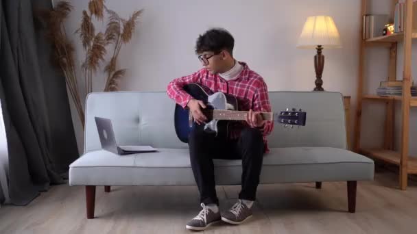 Young Man Playing Guitar Learning Using Laptop Computer Video Lessons — 图库视频影像