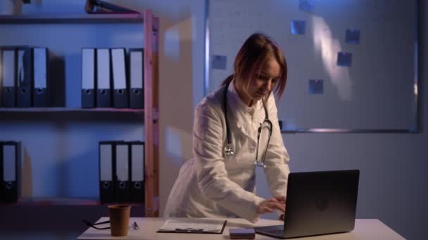 Female Doctor Typing Results Clipboard Laptop Computer Standing Table Doctors — Vídeos de Stock