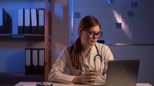 Joven Doctor Trabajando Turno Noche Bebiendo Café Usando Laptop Espacio — Vídeos de Stock