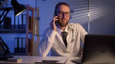 Male doctor working in clinic at night. Copy space