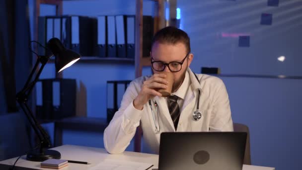 Doctor Using His Laptop Computer Drinking Coffee Working Table Night — 图库视频影像
