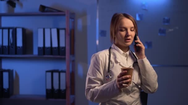Beautiful Female Doctor Drinking Coffee Making Call Hospital Consulting Room — Stockvideo