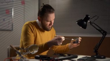 Man cleaning cooler system of laptop during maintenance or prophylaxis, removing dust with little brush. Concept of repairs service of electronic devices