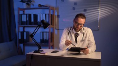 Doctor giving his younger colleague a piece of advice concerning the diagnosis while working at hospital. Copy space