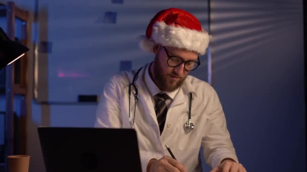 Doctor Wearing Red Santa Hat Working Christmas Eve Copy Space — Vídeo de stock