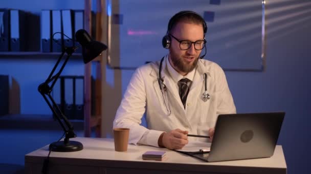Doctor Wearing Headset Sitting Desk Laptop Night Shift Copy Space — Vídeo de stock