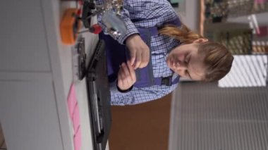 Woman repairing a laptop with a screwdriver in repair shop. Maintenance engineer support. Electronic technology development concept. Vertical video