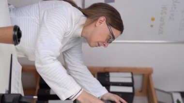 Woman healthcare personnel looking at brain x-ray radiographic image, ct scan, mri, clinic office background. Radiology department. Vertical video. Copy space