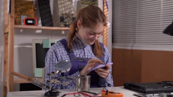 Female Repairman Repairing Laptop Service Relaxing Workplace Using Smartphone Playing — Vídeos de Stock