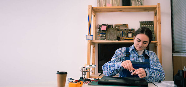 Repairs and diagnostics breakdowns of laptop in professional service center. Electronic master detach detail of laptop in workshop using screwdriver. Copy space. Banner