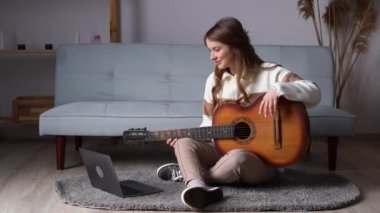Guitar tutorial with laptop. Music course. Technology and leisure. Teacher teaching how to play an instrument. Recording online music at home. Copy space