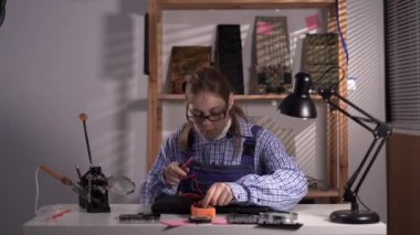 Female technician check of damaged laptop computer with multimeter. Computer repair and upgrade concept