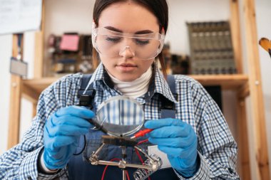 Desktop with broken disassembled laptop. Electronic parts of pc motherboard, circuit board, microprocessor. Analysis computer board through magnifying glass. Copy space
