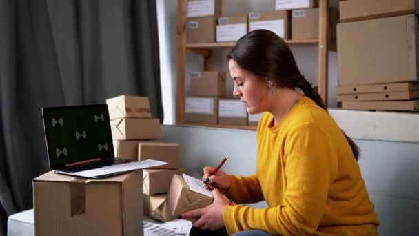 小企業を開始中小企業のオーナー女性起業家は ボックスで作業し ボックスをパックする準備をオンライン注文を確認します 顧客に販売 いくつかのオンラインビジネスアイデアのコンセプト — ストック動画