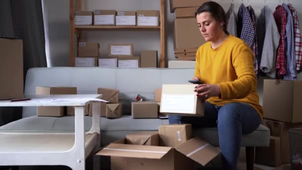 Small Online Business Owner Preparing Small Cardboard Parcel Postage Deliveries — Wideo stockowe