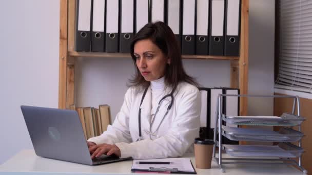 Γυναίκα Γιατρός Ελέγχει Ιστορικό Των Ασθενών Και Χρησιμοποίησε Ένα Φορητό — Αρχείο Βίντεο