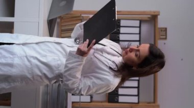 Female medicine doctor writing something on clipboard. Medical care, insurance, career concept. Physician ready to examine patient and help. Copy space