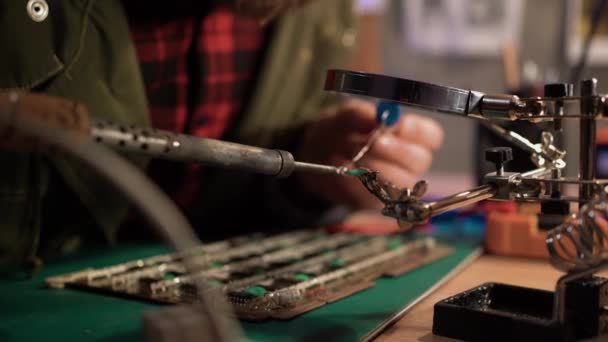 Volwassen Ingenieur Repareert Een Deel Van Printplaat Met Een Soldeerbout — Stockvideo