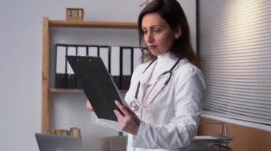 Female medicine doctor reading something on clipboard. Medical care, insurance, prescription or career concept. Physician ready to examine patient and help. Copy space