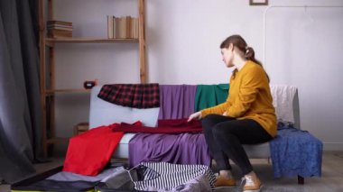Çekici kız elbiselerini evde bir bavula koyar. Güney ülkeleri. Tatil ve seyahat. Yolculuk ve macera kavramı. Boşluğu kopyala