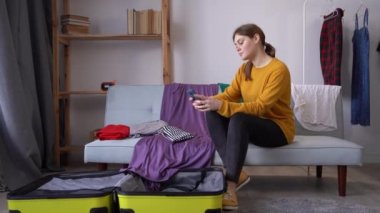 Seyahat etmeyi planlayan genç bir gezgin ya da akıllı telefondan bilgi almak için uygulama, seyahat konseptini kullanıyor.