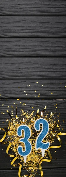 Modrá Slavnostní Svíčka Zlaté Konfety Tmavém Dřevěném Pozadí Narozeninové Přání — Stock fotografie
