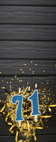 Modrá Slavnostní Svíčka Zlaté Konfety Tmavém Dřevěném Pozadí Narozeninové Přání — Stock fotografie