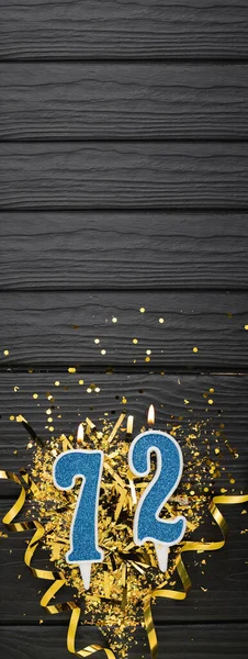 72号蓝色庆祝蜡烛和黑色木制背景的金冠 72岁生日贺卡 周年纪念和生日的概念 垂直横幅 复制空间 — 图库照片