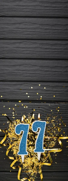 Numero Candela Blu Celebrazione Confetti Oro Sfondo Legno Scuro 77Esimo — Foto Stock