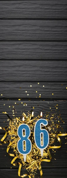 Nummer Blauwe Viering Kaars Gouden Confetti Donkere Houten Ondergrond 86Ste — Stockfoto