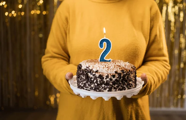 生日2 女人拿着生日蛋糕和点燃的蜡烛2号在装饰的背景下 在家里庆祝生日 复制空间 — 图库照片