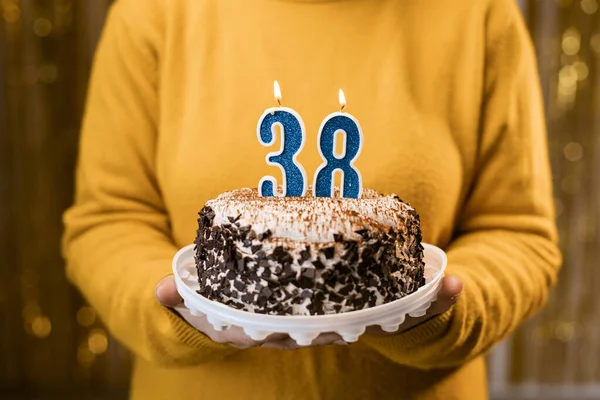 一个女人在庆祝生日的时候 手里拿着一个有38支蜡烛的美味蛋糕 生日假期派对的人的概念 靠近点 — 图库照片