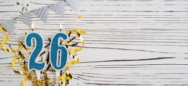 Beyaz ahşap arka planda 26 numaralı mavi kutlama mumu. Mutlu doğum günü mumları. Doğum günü, yıldönümü, önemli tarih, tatil kavramı. Uzayı kopyala Pankart