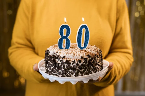 お祝いのケーキを持っている女性80誕生日パーティーを祝いながらキャンドル 誕生日パーティーの人々の概念 クローズアップビュー — ストック写真