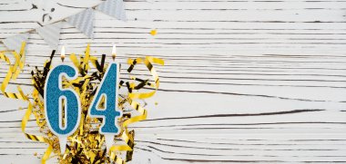 Beyaz ahşap arka planda 64 numaralı mavi kutlama mumu. Mutlu doğum günü mumları. Doğum günü, yıldönümü, önemli tarih, tatil kavramı. Uzayı kopyala Pankart