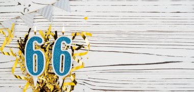 Beyaz ahşap arka planda 66 numaralı mavi kutlama mumu. Mutlu doğum günü mumları. Doğum günü, yıldönümü, önemli tarih, tatil kavramı. Uzayı kopyala Pankart