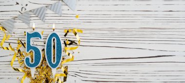 Mavi mum numarası, 50 haneli. Doğum günü tebrik kartında 50 yazılıydı. Yıldönümü konsepti. Üst Manzara. Tahta beyaz arka planda rakam. Sayısal rakam, kutlama etkinliği. Boşluğu kopyala