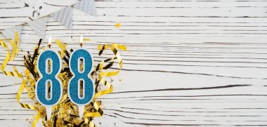 88 numaralı mavi kutlama mumu beyaz ahşap arka planda. Mutlu doğum günü mumları. Doğum günü, yıldönümü, önemli tarih, tatil kavramı. Uzayı kopyala Pankart