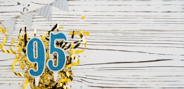 Beyaz ahşap arka planda 95 numaralı mavi kutlama mumu. Mutlu doğum günü mumları. Doğum günü, yıldönümü, önemli tarih, tatil kavramı. Uzayı kopyala Pankart