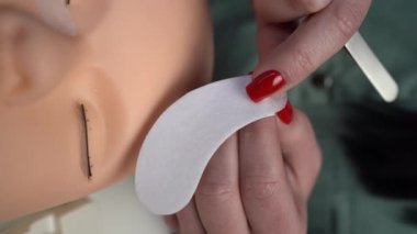 Güzellik salonunda kirpik uzatma eğitimi. Eğitim ve işaretleme. Manken kafa, kapat. Dikey video