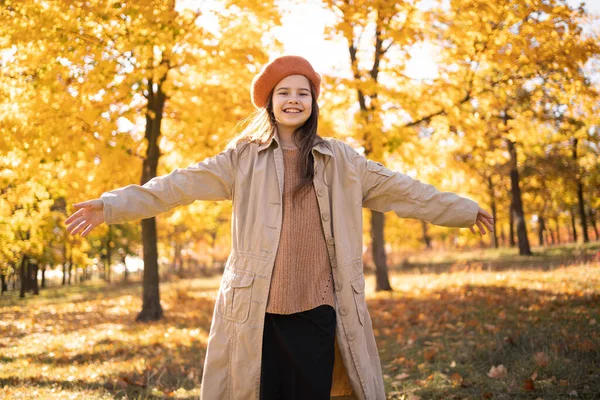 Stock image Happy young girl enjoying life and freedom during autumn season with closed eyes on the nature, breathing deeply in park with foliage in background. copy space