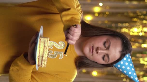 女人用打火机在生日蛋糕上点25支蜡烛 微笑的女孩拿着生日蛋糕 看着相机在派对上 Pov 垂直录像 — 图库视频影像