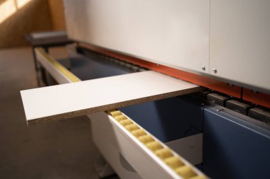 Kenar bantlı bir makinenin tahta parçasının yakın çekimi. Mobilya fabrikasında ahşap işçiliği. Boşluğu kopyala